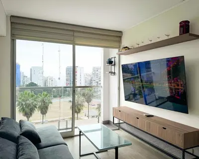 a living room with a couch and a large window at Peruvian Apartments Barranco 904 in Lima