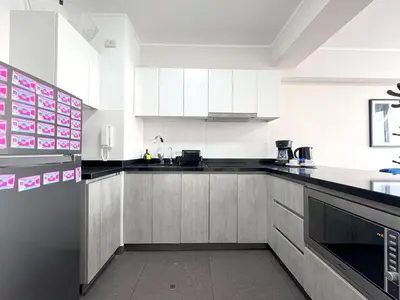 a kitchen with white cabinets and black counter tops at Peruvian Apartments Barranco 904 in Lima