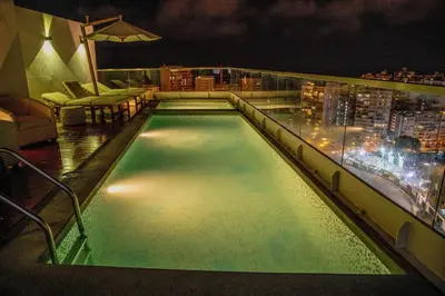 a swimming pool on top of a building at night at Peruvian Apartments Barranco 904 in Lima