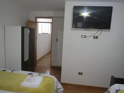 a room with a flat screen tv on the wall at Hospedaje EL RINCONCITO II - Cerca al Aeropuerto Jauja in Jauja