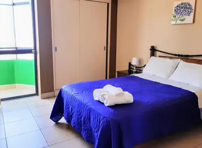 a bedroom with a blue bed with towels on it at Sol de Paracas Apart Hotel Pisco in Pisco