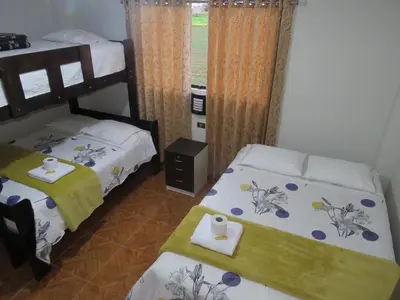 a bedroom with two beds and a window at DEPARTAMENTO-Hospedaje EL RINCONCITO II 100m2, 3hab, 4baños, sala, comedor, cocina in Jauja