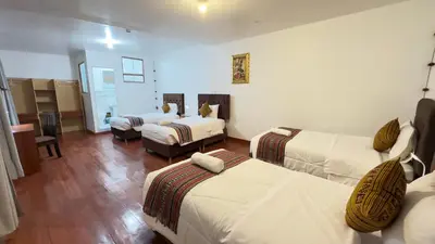 a hotel room with two beds and a living room at Casona Libertrek Inn in Cusco