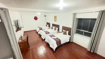 a group of four beds in a room at Casona Libertrek Inn in Cusco
