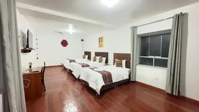 a group of four beds in a room at Casona Libertrek Inn in Cusco