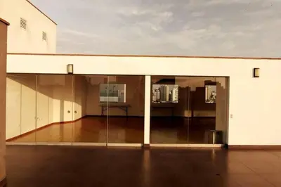 a large white building with sliding glass doors at Excellent apartment, access to pool, grills, ballroom in Lima