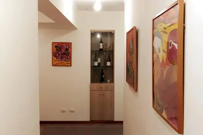 a hallway with paintings and a shelf of wine bottles at Excellent apartment, access to pool, grills, ballroom in Lima