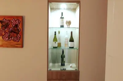 a mirror with several bottles of wine on a shelf at Excellent apartment, access to pool, grills, ballroom in Lima