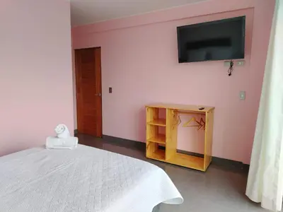 a bedroom with a bed and a tv on the wall at Hotel Sunlight in Paracas