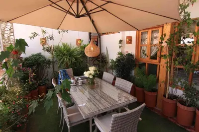 a table and chairs with an umbrella in a garden at Bamba House Cusco in Cusco