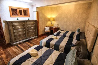 a bedroom with two beds and a dresser at Bamba House Cusco in Cusco