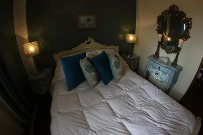 a bedroom with a white bed with blue pillows at Bamba House Cusco in Cusco