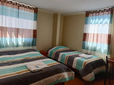 two beds in a room with curtains at Hotel El Gran Valletero in Cotahuasi