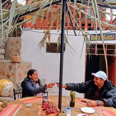 two people sitting at a table with wine glasses at Hotel El Gran Valletero in Cotahuasi