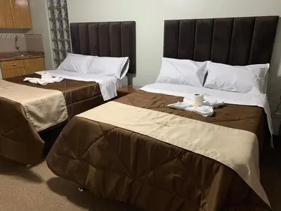 two beds in a hotel room with towels on them at Grand Hotel Betsy in Lima