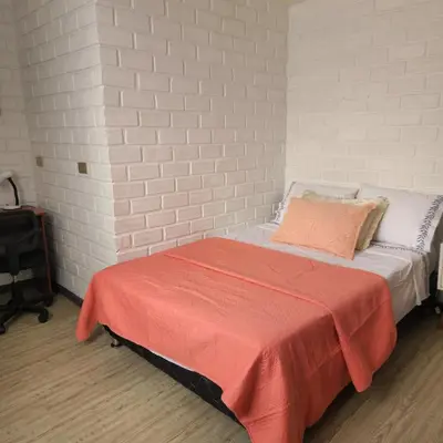 a bedroom with a bed with a red blanket on it at Acogedor APT a 20 min Aeropuerto in Lima