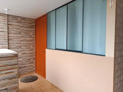 a bathroom with a brick wall and a window at Acogedor APT a 20 min Aeropuerto in Lima