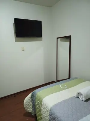 a bedroom with a bed and a flat screen tv at Habitación acogedora Orué in Lima