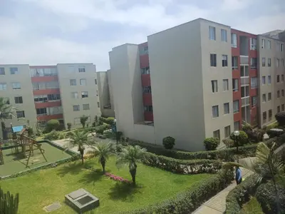 an aerial view of a building with palm trees and a park at Habitación acogedora Orué in Lima