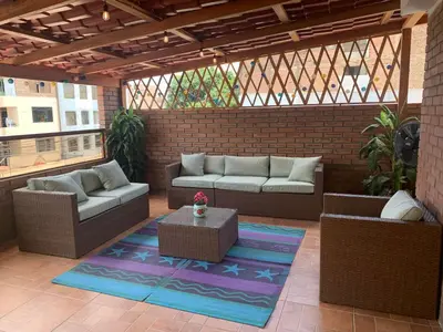 a patio with couches and a table on a brick wall at San Miguel, lindo depa, 3 camas, internet y cable in Lima