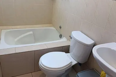 a bathroom with a toilet and a bath tub at Qori Garden Apartment in Cusco