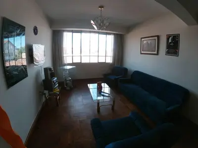 a living room with a blue couch and a table at Departamento en el centro histórico del Cusco in Cusco