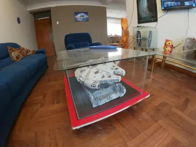 a glass table in a living room with a blue couch at Departamento en el centro histórico del Cusco in Cusco