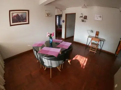 a dining room with a table with a vase of flowers at Departamento en el centro histórico del Cusco in Cusco