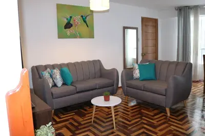 a living room with two couches and a table at El colibrí de San Blas in Cusco