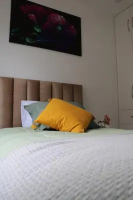 a bed with a yellow pillow on top of it at El colibrí de San Blas in Cusco