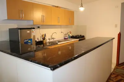a kitchen with a black counter top and a sink at El colibrí de San Blas in Cusco