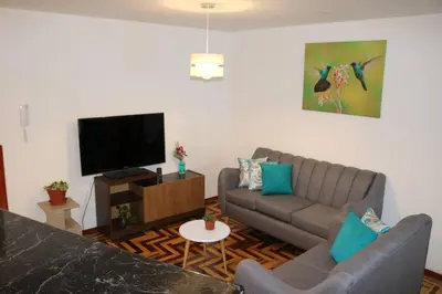 a living room with a couch and a flat screen tv at El colibrí de San Blas in Cusco