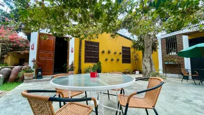 a table and chairs in front of a yellow building at Serenity Lodge in Ica