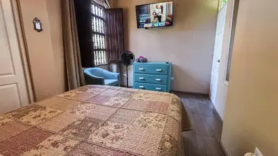 a bedroom with a bed and a blue dresser and a window at Serenity Lodge in Ica