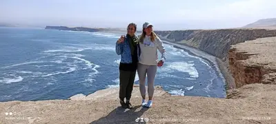 a man and woman standing on the edge of a cliff at ALOJAMIENTO ISLA BLANCA in Paracas