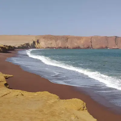 a beach with the ocean and a rocky coastline at ALOJAMIENTO ISLA BLANCA in Paracas