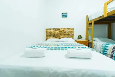 a bedroom with a bed with two bunk beds at ALOJAMIENTO ISLA BLANCA in Paracas
