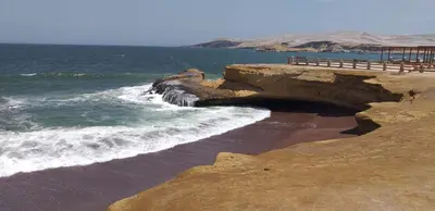 a beach with waves crashing on the shore at ALOJAMIENTO ISLA BLANCA in Paracas