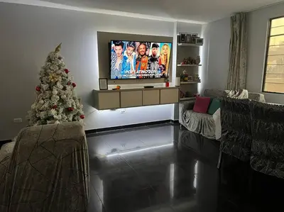 a living room with a christmas tree and a television at Espacio para ti y tu familia in Lima