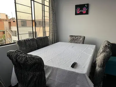 a white table and chairs in a room with a window at Espacio para ti y tu familia in Lima