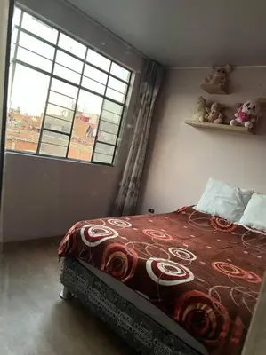 a bedroom with a bed and a window with teddy bears at Espacio para ti y tu familia in Lima