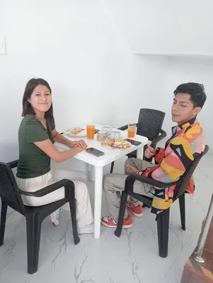a man and woman sitting at a table with food at Hurin Hotel in Ica