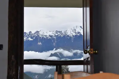 a view of a snow covered mountain through a window at CasaNostra Choquequirao in Cachora