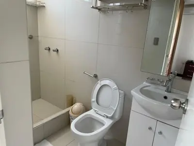 a white bathroom with a toilet and a sink at Lima HOUSE MILANI in Lima