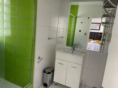 a bathroom with a sink and a shower with a mirror at Lima HOUSE MILANI in Lima