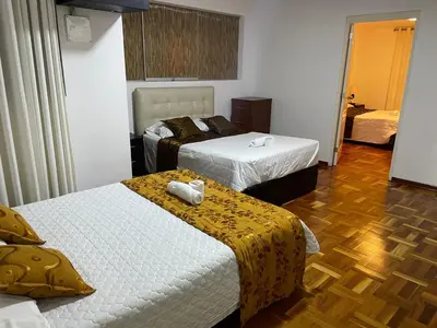 a bedroom with two beds and a wooden floor at Lima HOUSE MILANI in Lima