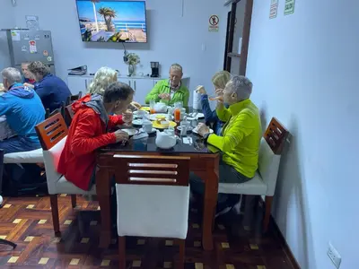 a group of people sitting at a table eating food at Lima HOUSE MILANI in Lima