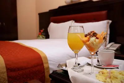 a hotel room with a tray of food and drinks on a bed at Hotel Princesa in Lima