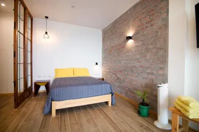 a bedroom with a bed and a brick wall at Kauhuhu Casa Hotel in San Bartolo