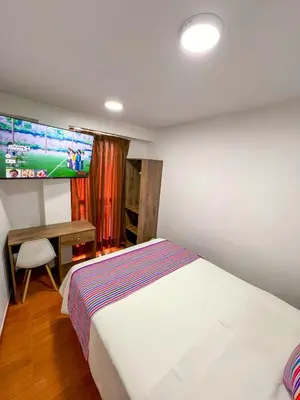 a bedroom with a bed and a desk and a tv at Golden Paris Hotel 